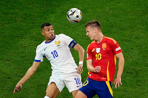 Dani Olmo and Kylian Mbappe compete for the ball 